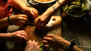 Image of hands preparing a meal in Sumer's socially engaged project Under the fig tree.